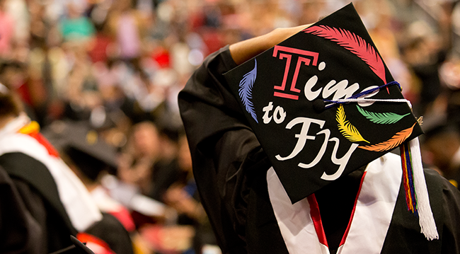 image of student holding her graduation cap with the words time to fly