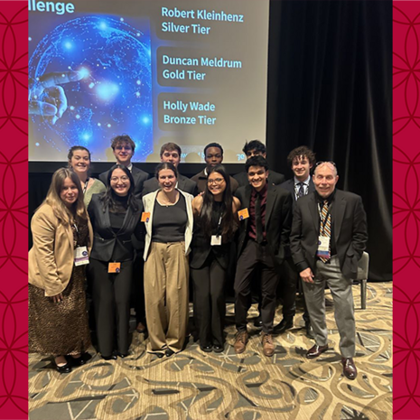 image of students and Chris Swann standing in front of a projection screen in a group photo