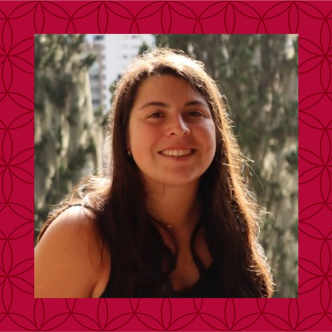 image of Elena standing outside wearing a black sleeveless shirt and smiling at the camera