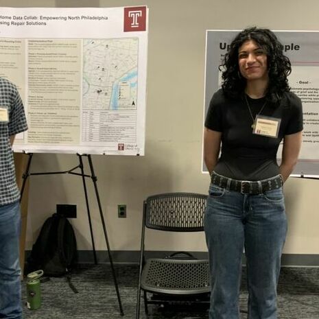 image of two students and their posters on display at the showcase