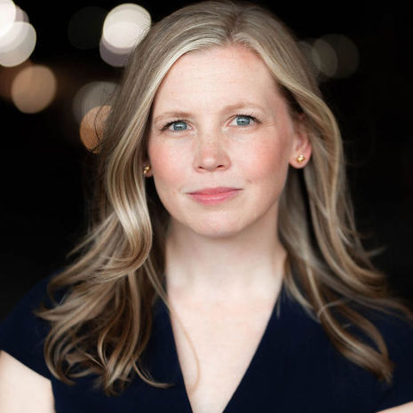 image of Laura McGrath in a black shirt standing against a black background