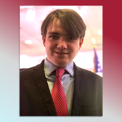 image of Luke Christopher in a red tie, blue button down shirt and black suit jacket