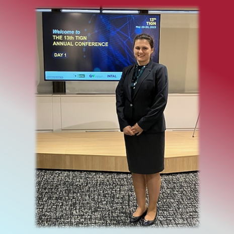 image of Olga standing in a blue skirt suit in from of a conference screen