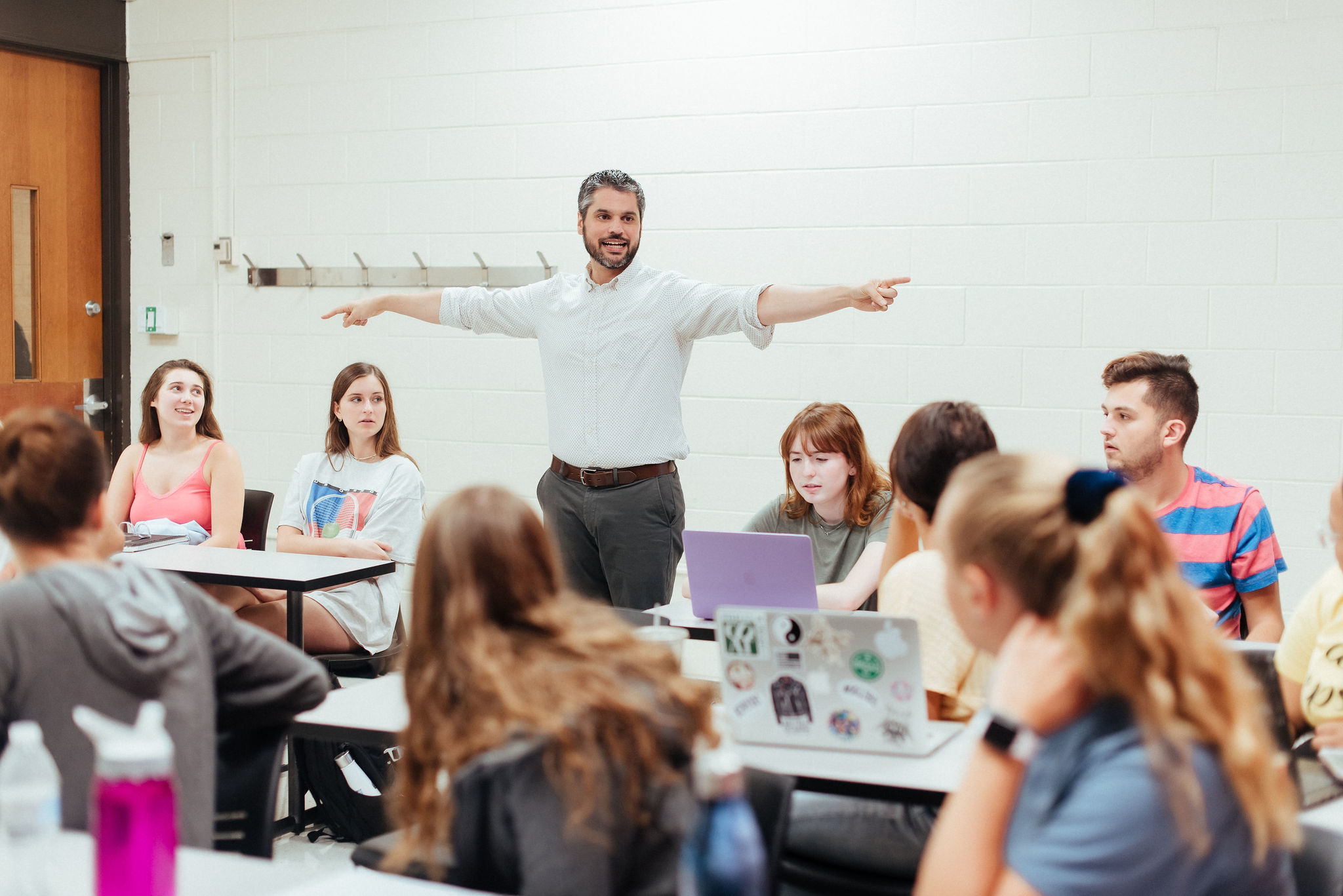 professor interacting with students at back of classroom