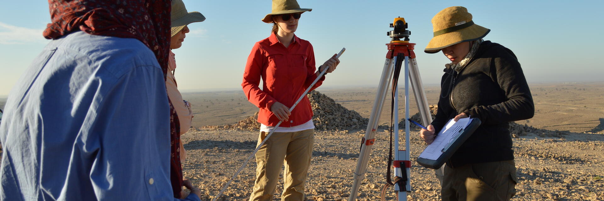 image of instructor with students in Oman at a dig site