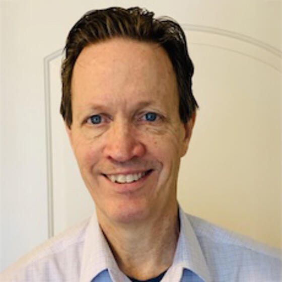 Charles Swanson smiling and staring into the camera