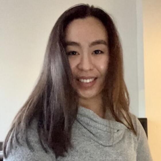 image of Han Le wearing a grey sweater and smiling at the camera