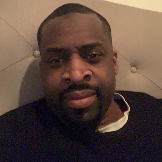 Latif Davis in a black shirt staring into the camera