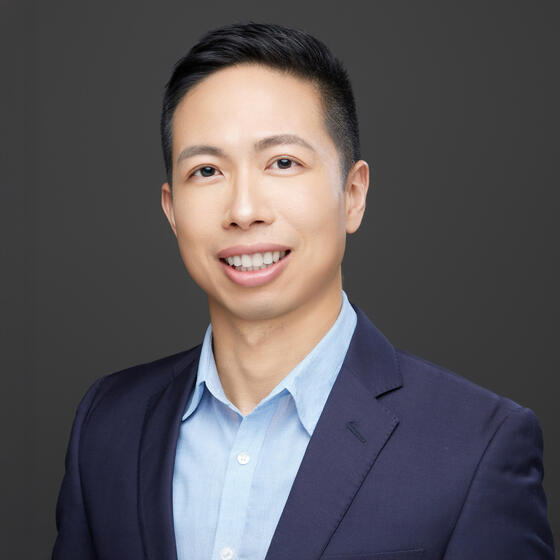 image of Steven smiling at the camera wearing a blue suit
