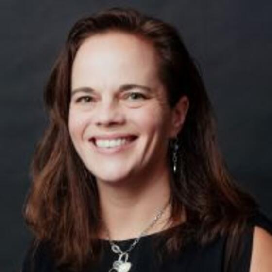 Deborah Drabick in a black shirt smiling and staring into the camera