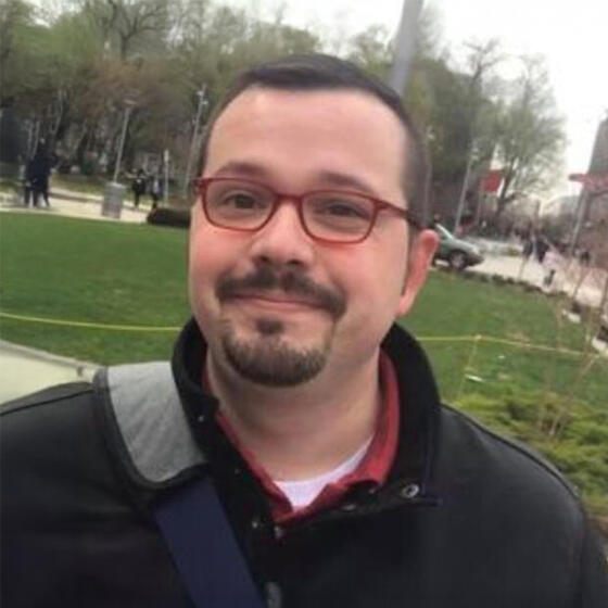 Sean D. Harris in a black shirt outside smiling into the camera