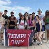 image of LASS students standing in a group holding the Temple banner