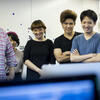 image of TUJ students and instructor looking at a computer screen