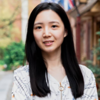 image of Ching-hsuan wearing a floral blouse smiling at the camera with the city behind her