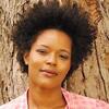 image of Yolanda WSisher in a red shirt standing against a tree