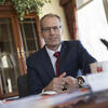 Richard Deeg in his office wearing a navy suit with a red tie smiling and staring into the camera