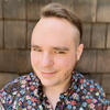 Joseph Johnson in a floral shirt smiling into the camera