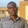 image of Nii Quaye standing with the city nehind him smiling at the camera