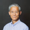 Shanyang Zhao in a blue shirt staring into the camera