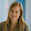Chelsea Helion in a green shirt smiling and staring into the camera