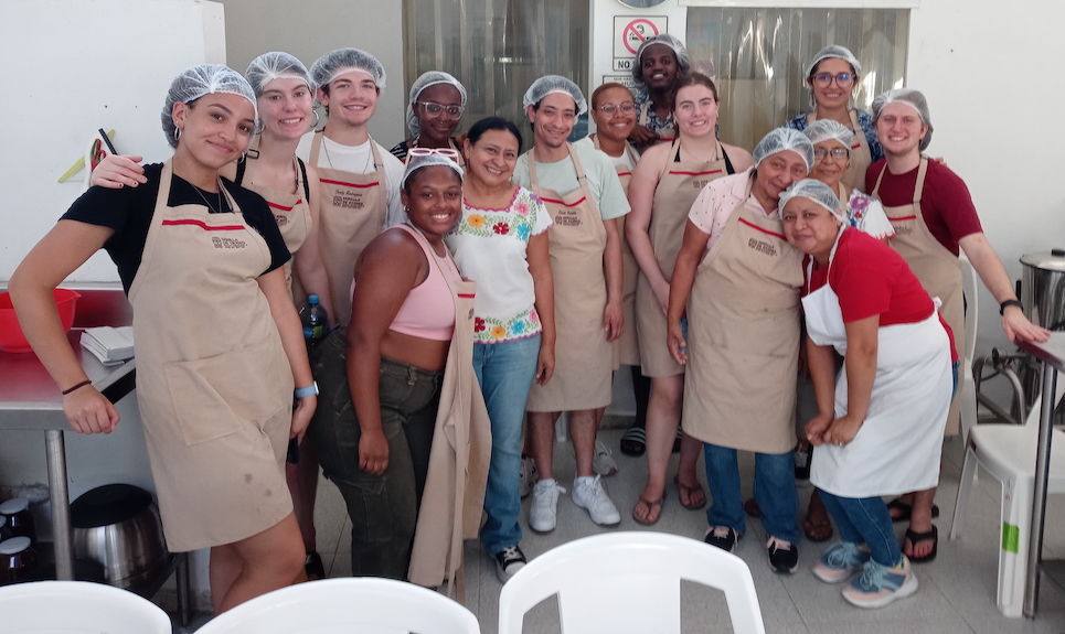 image of a group of study abroad students and locals standing in a kitchen 