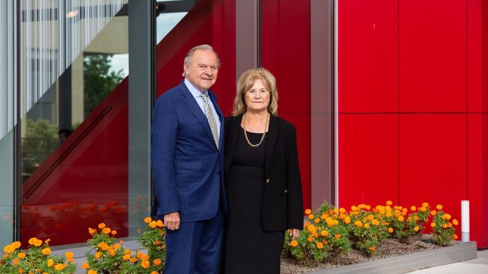 Leonard and Helena standing in front of the new Mazur Hall, wearing a blue suit and a black dress