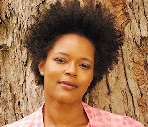 image of Yolanda WSisher in a red shirt standing against a tree