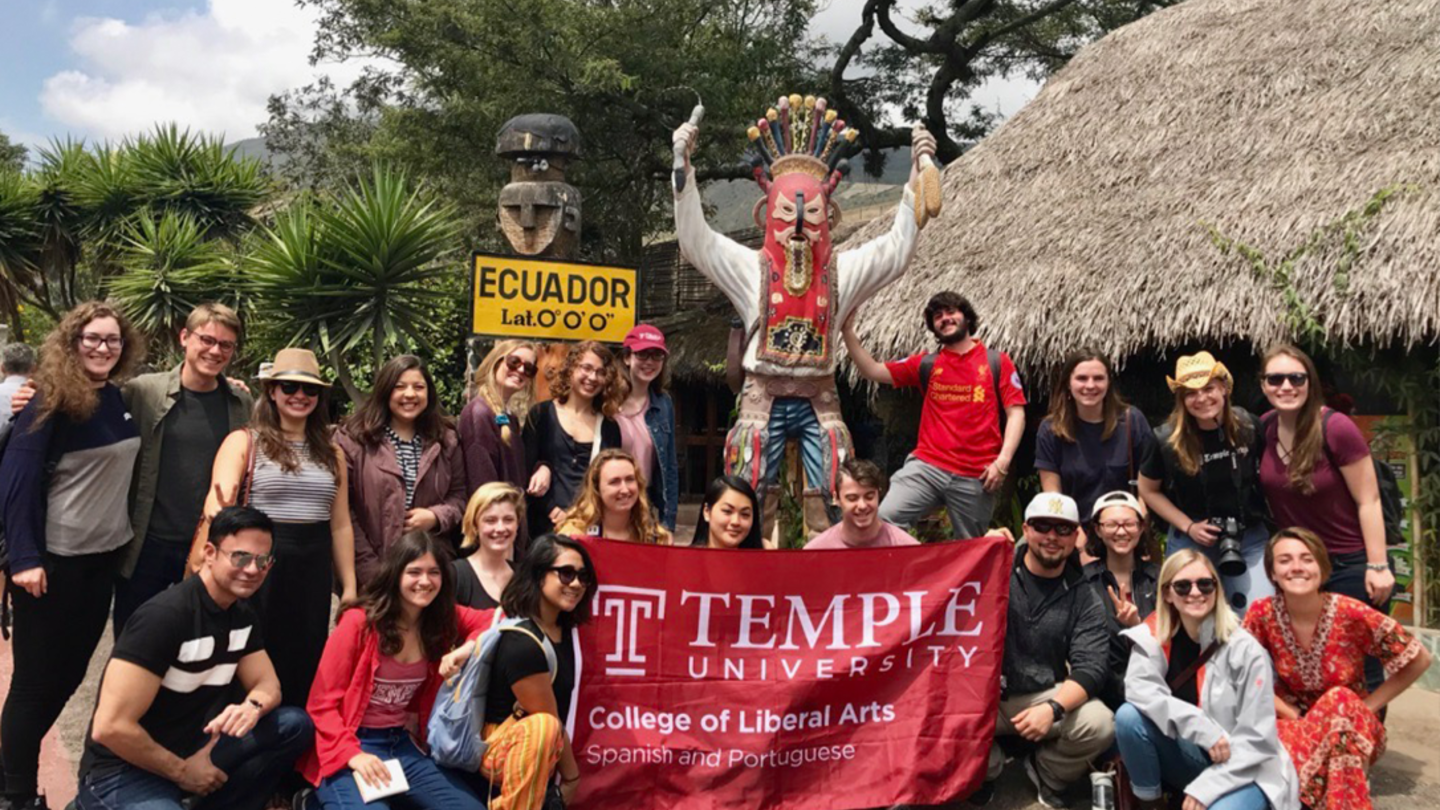 Latin American Studies Students hold College of Liberal Arts banner while abroad in Ecuador