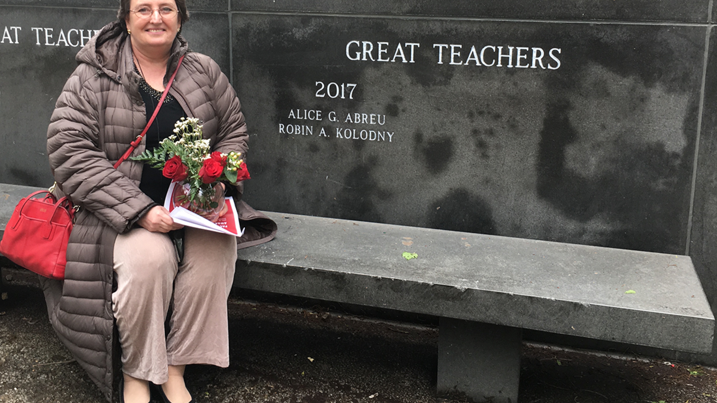 Professor of Political Science and Chair of the Department of Political Science Robin Kolodny sits next to her name engraved in the wall at Founder's Garden