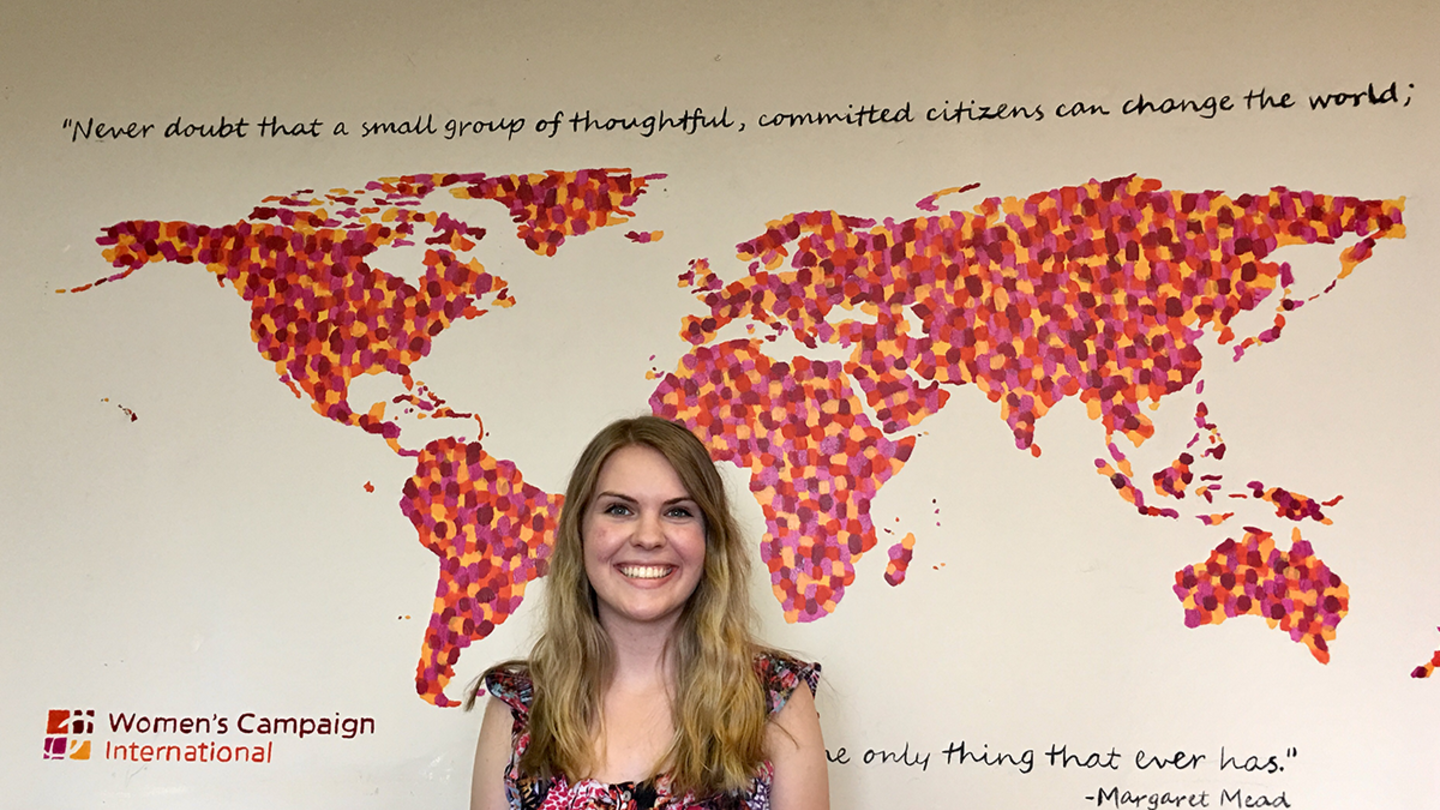 Amanda Morrison stands in front of a wall map at Women's Campaign International