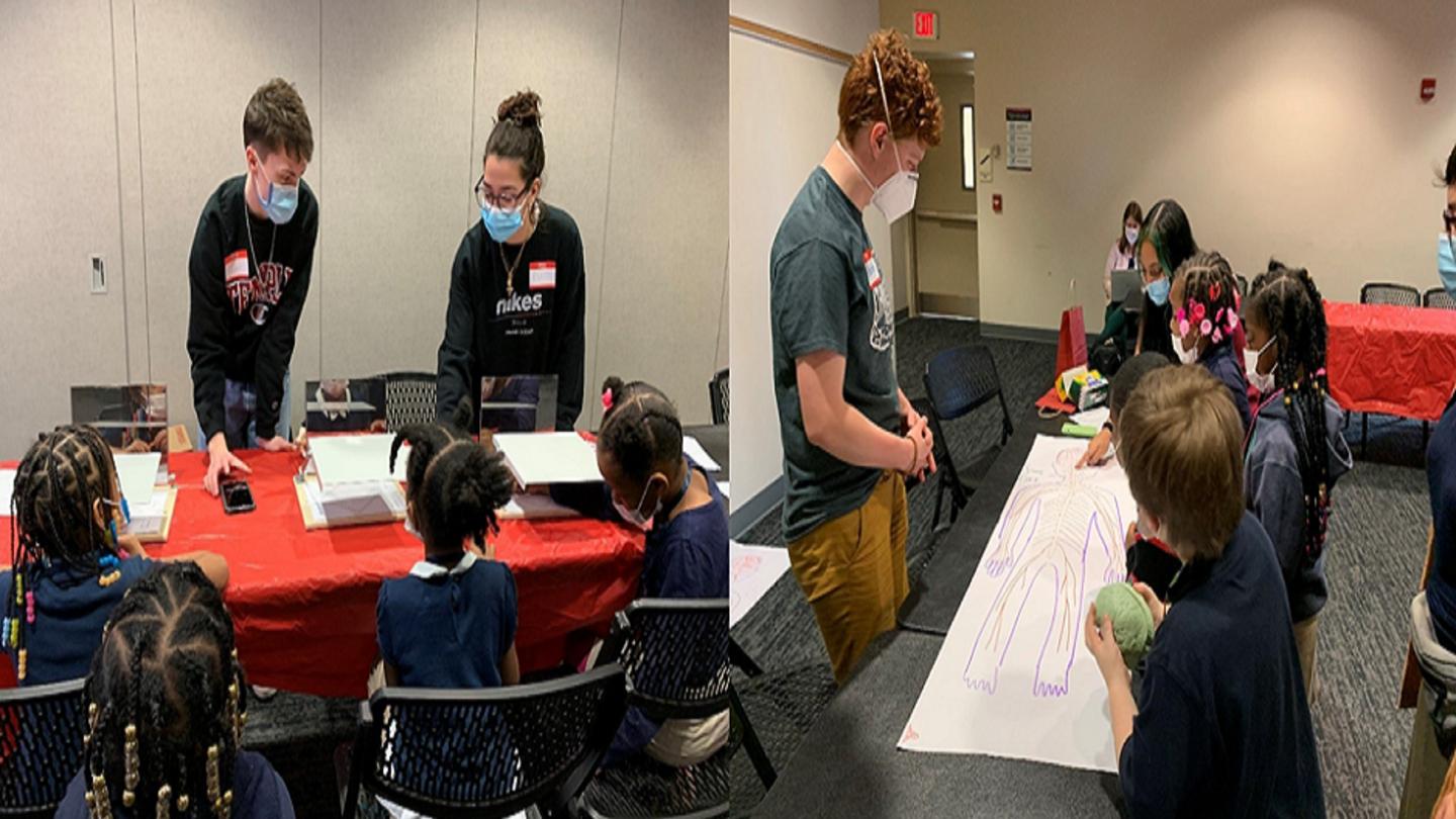 (Picture 1, L): Undergraduates Cooper Sharp and Cleopatra Nehme demonstrate a mirror-tracing task to the first-grade visitors. (Picture 1, R): Undergraduates Gideon Morgan and Aleena Atahar help children draw the nervous system. image of students with elementary school kids at Brain Awareness week