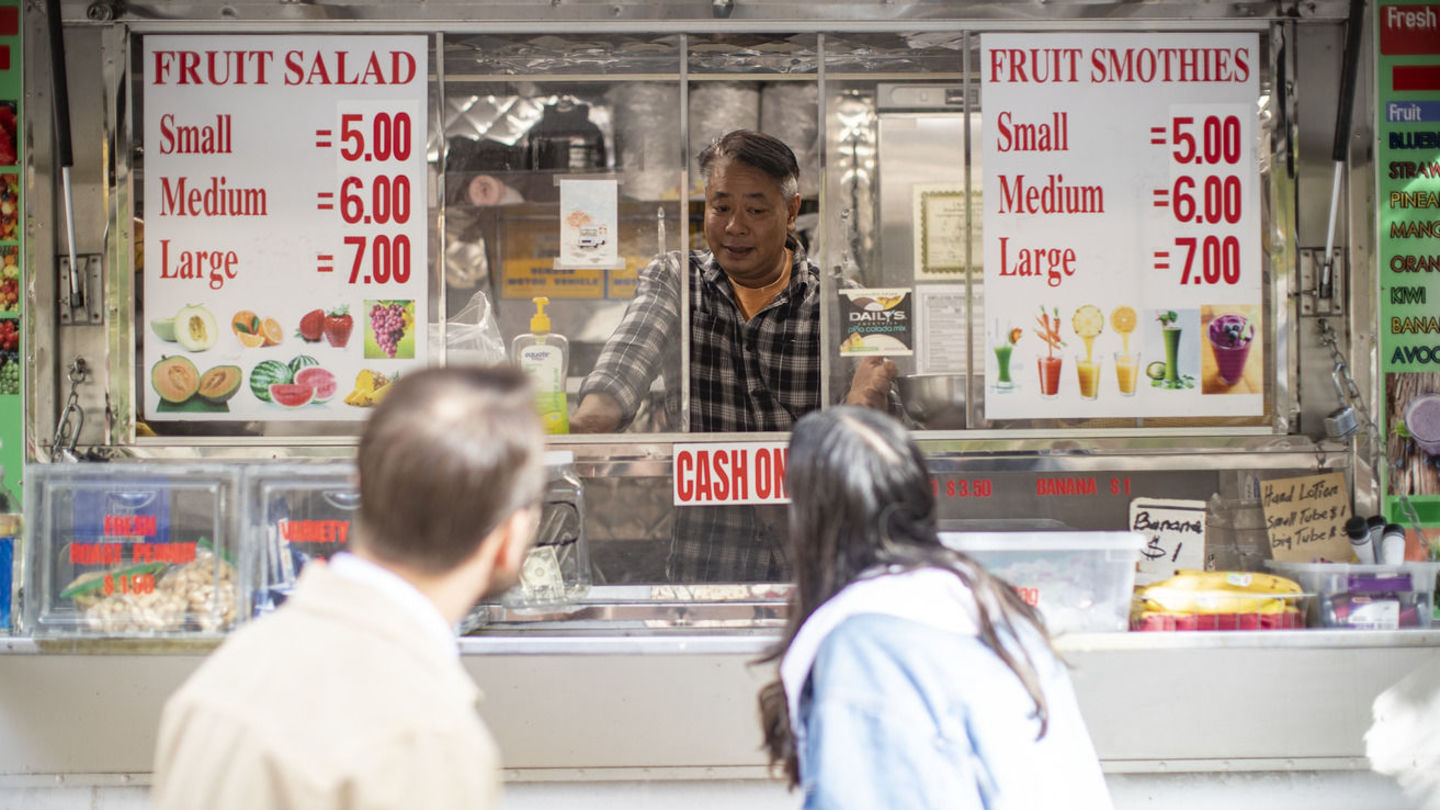 Image of students interviewing a food truck operator.