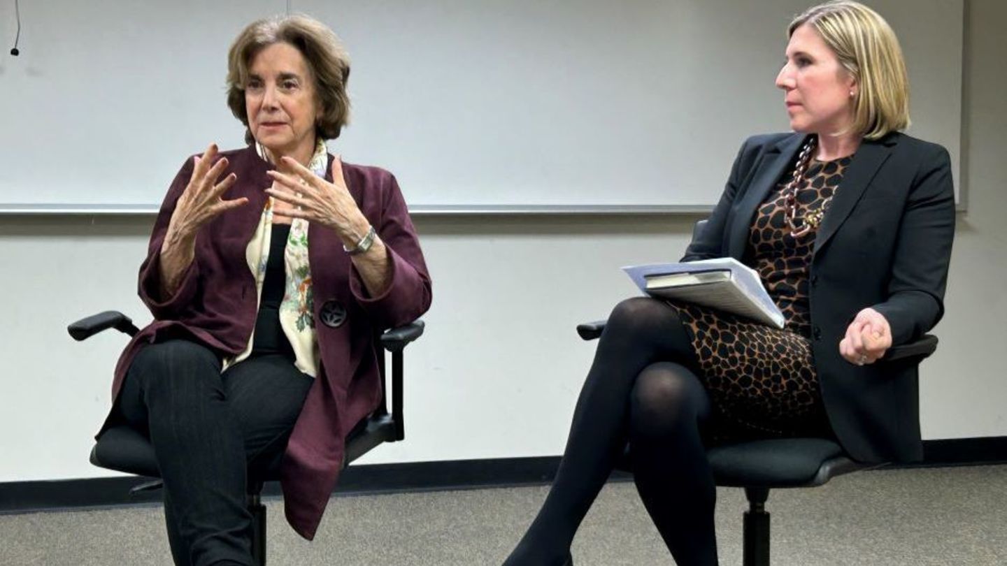 image of Marjorie Margolies sitting having a conversation with a member of the womens justice league