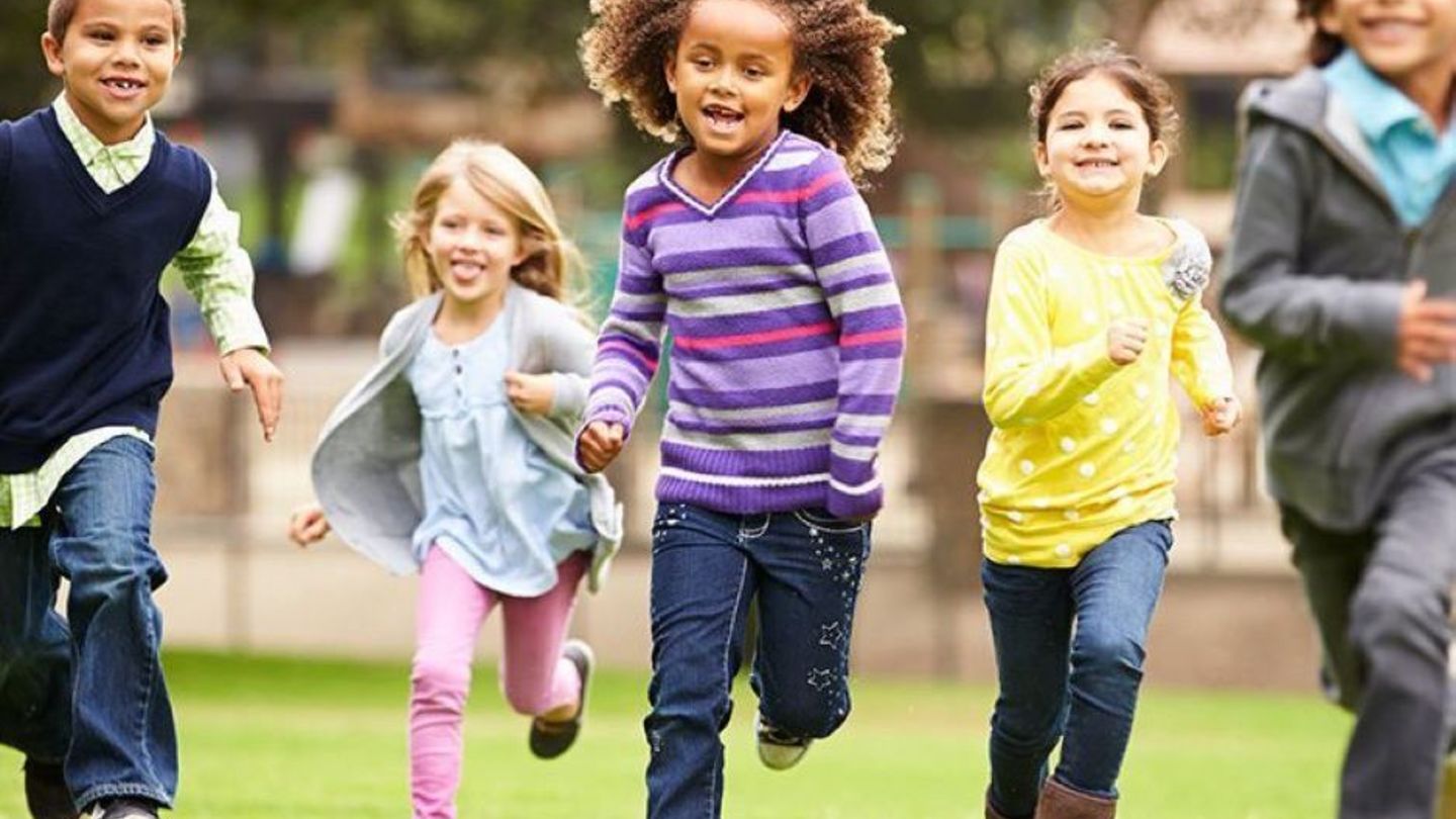 image of children running and playing in the grass