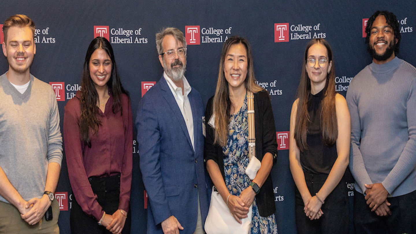 image of LAURA students and BOV member standing in front of a CLA backdrop