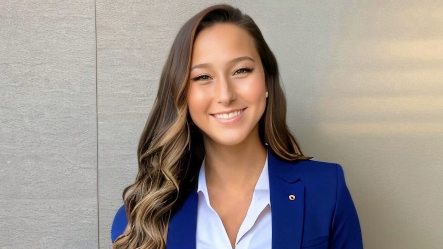 headshot of Mary wearing a blue blazer and button down shirt