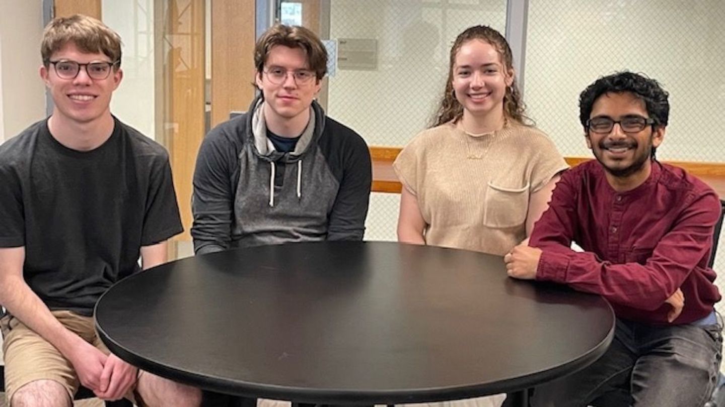 image of students sitting around a table in the Economics lounge
