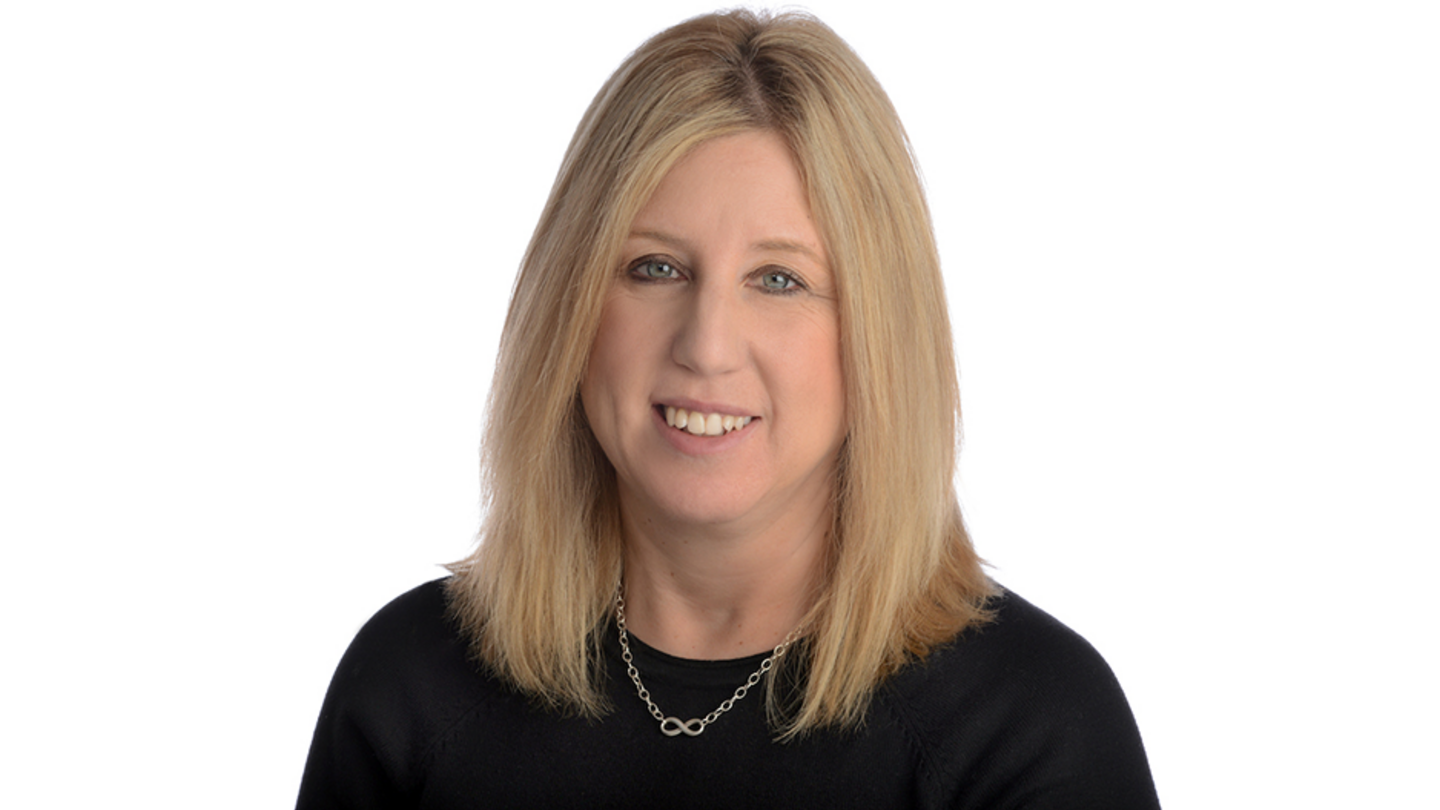 image of cindy wearing a black top smiling at the camera against a white background